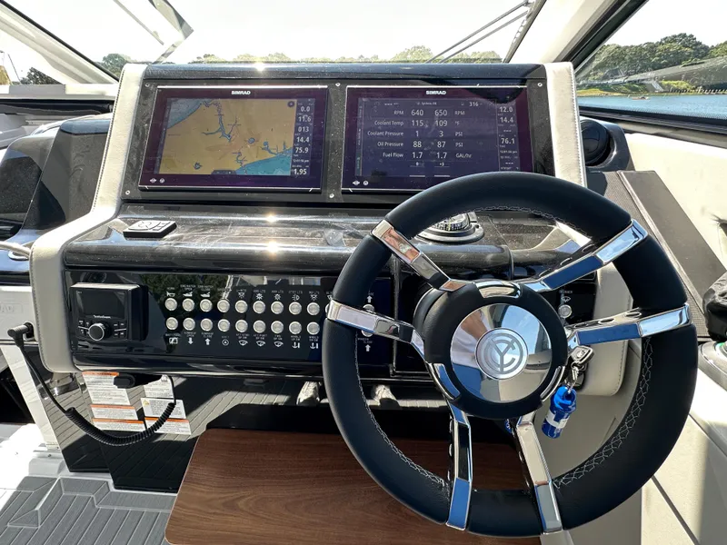 Slide: The Image of 2024 Cruisers Yachts 42 GLS Outboard helm with dual Simrad displays and modern steering wheel. - 22
