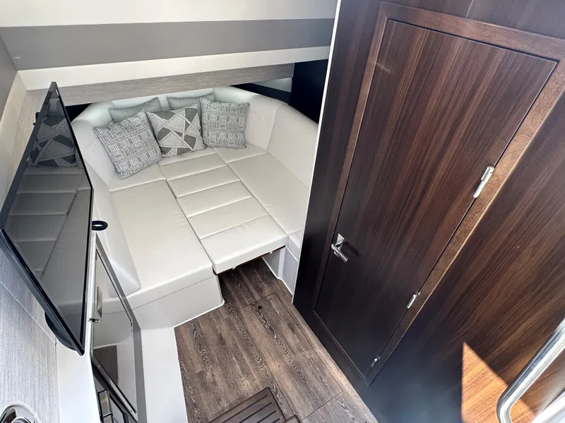 Slide: The Image of 2024 Cruisers Yachts 42 GLS Outboard cabin with white leather seating and wood accents. - 23