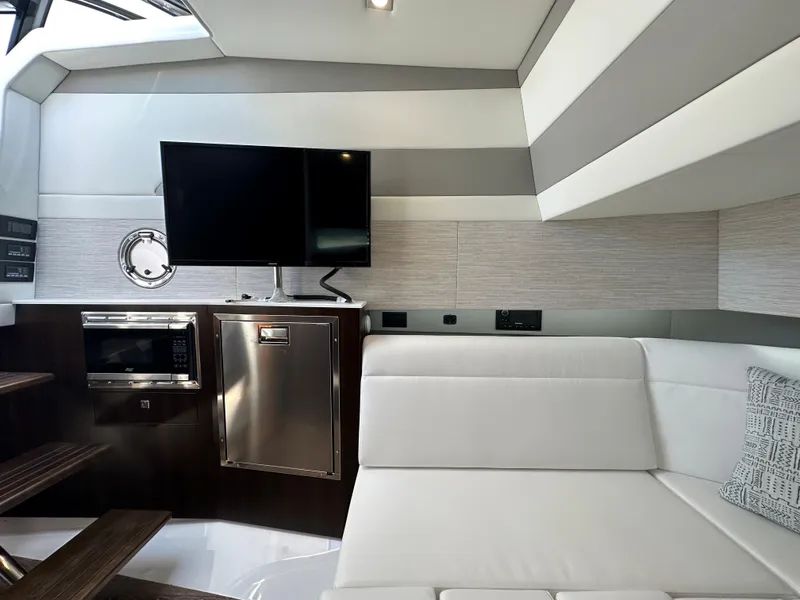 Slide: The Image of Interior of 2024 Cruisers Yachts 42 GLS Outboard with TV, microwave, and white seating. - 25