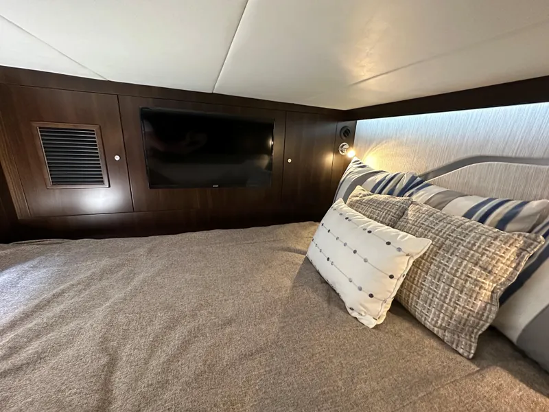 Slide: The Image of Luxurious cabin interior of 2024 Cruisers Yachts 42 GLS Outboard with TV and plush bedding. - 28