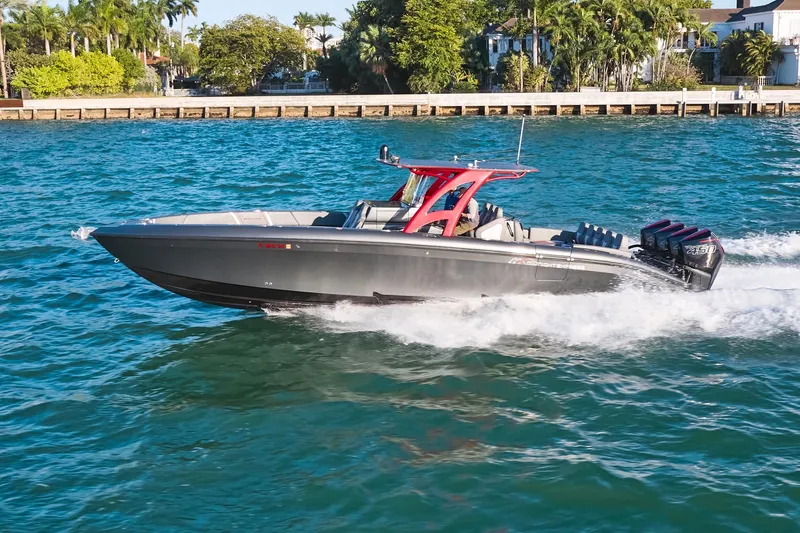 The Image of 2020 Midnight Express 37 Open boat cruising on blue water near a lush shoreline. - 0