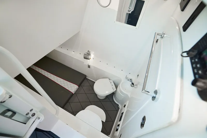 Slide: The Image of Interior of 2020 Midnight Express 37 Open boat, featuring compact bathroom and seating area. - 18