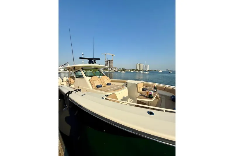 Slide: The Image of 2024 Scout 400 LXF luxury boat docked with scenic waterfront view. - 5