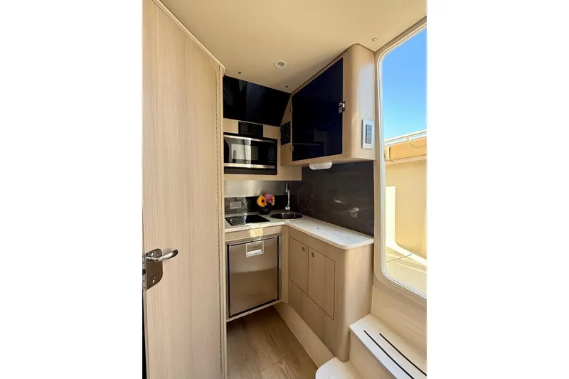 Slide: The Image of 2024 Scout 400 LXF boat interior kitchen with modern appliances and sleek design. - 8