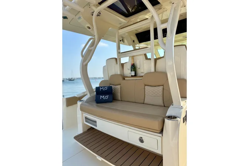 Slide: The Image of Luxurious seating on 2024 Scout 400 LXF boat with champagne and cushions. - 9
