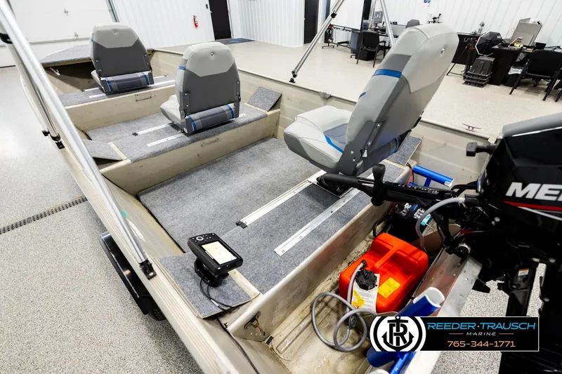 Slide: The Image of 1999 Tracker Pro Deep V-16 boat interior with seating and motor, in a showroom. - 10