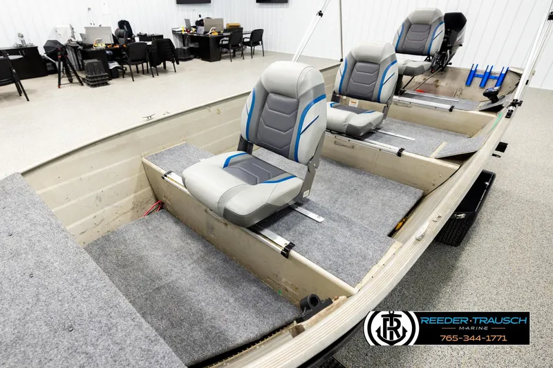 Slide: The Image of 1999 Tracker Pro Deep V-16 boat interior with gray and blue seating in showroom. - 9