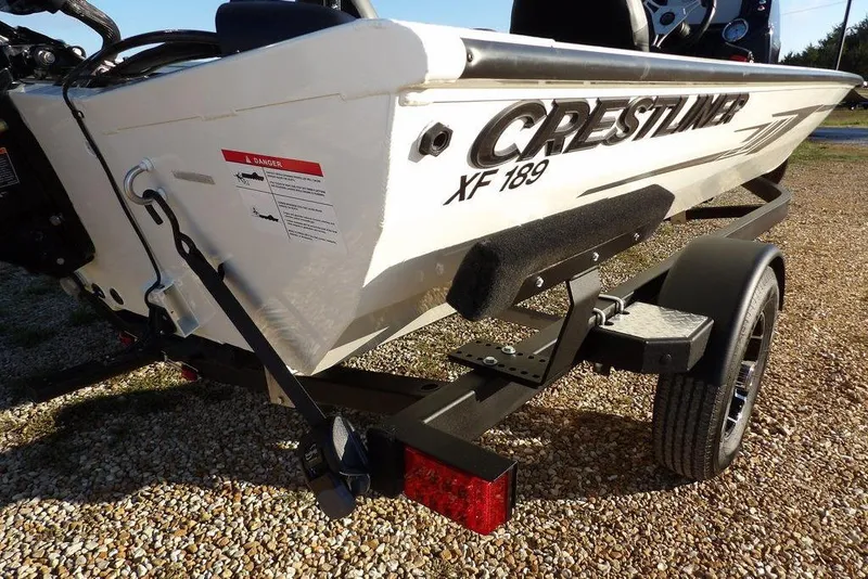 Slide: The Image of 2025 Crestliner XF 189 boat on trailer, rear view, parked on gravel. - 49