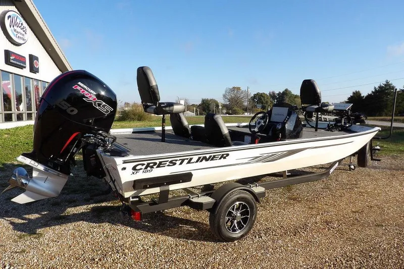 Slide: The Image of 2025 Crestliner XF 189 boat with Mercury engine, parked outside a marine center. - 6