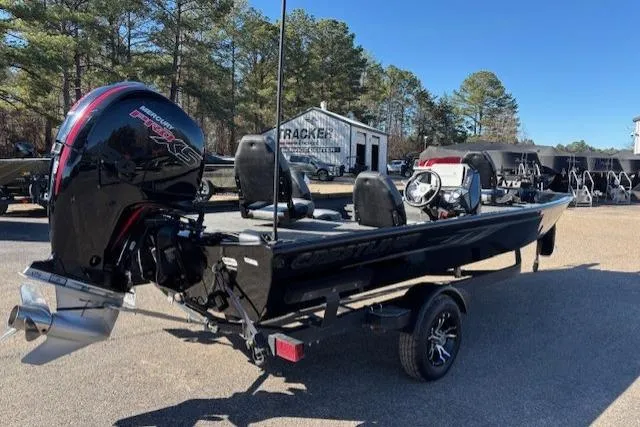 Slide: The Image of 2023 Crestliner XFC 189 boat with powerful outboard motor, parked outdoors. - 2