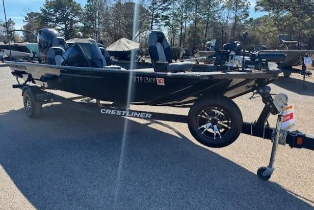 Slide: The Image of 2023 Crestliner XFC 189 boat on trailer, parked outdoors, surrounded by trees. - 3