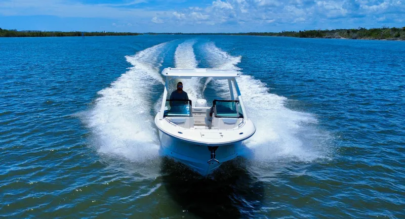 Slide: The Image of 2025 Robalo R257 Dual Console cruising on open water under clear skies. - 12