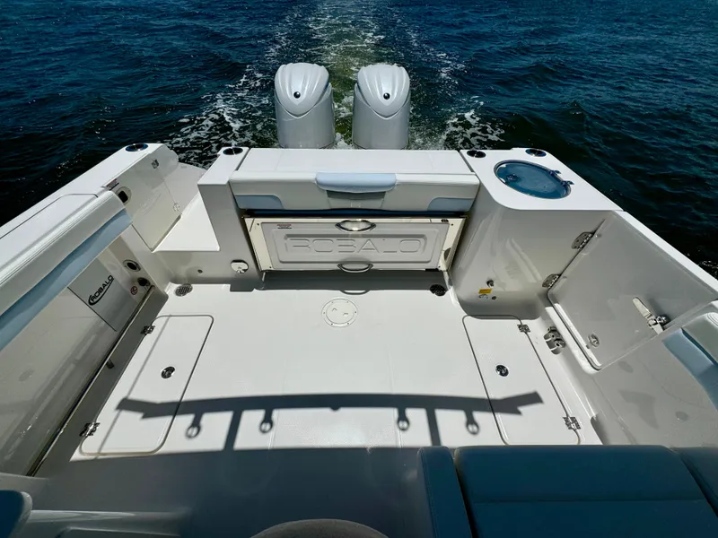 Slide: The Image of 2025 Robalo R257 Dual Console boat deck with twin engines on open water. - 18
