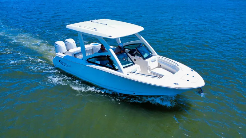 Slide: The Image of 2025 Robalo R257 Dual Console boat cruising on open water. - 2