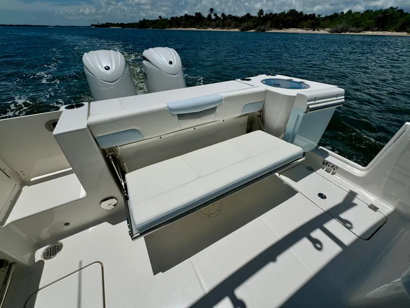 Slide: The Image of 2025 Robalo R257 Dual Console boat with foldable seating and twin engines on open water. - 20