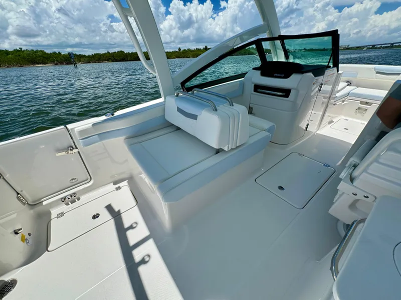 Slide: The Image of 2025 Robalo R257 Dual Console boat interior with white seating and open water view. - 21