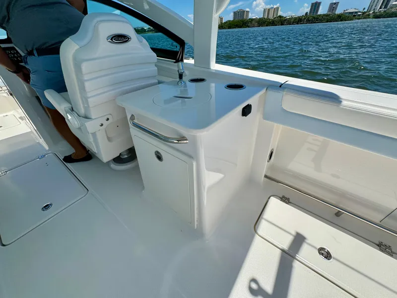 Slide: The Image of 2025 Robalo R257 Dual Console boat interior with seating and storage, on a sunny day by the water. - 24