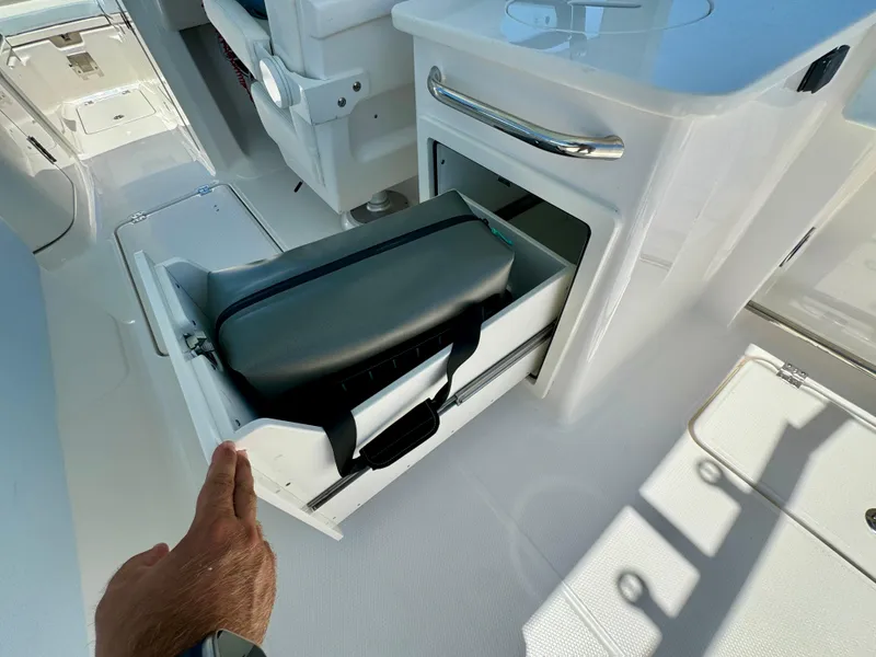Slide: The Image of 2025 Robalo R257 Dual Console boat with open storage compartment and bag. - 29