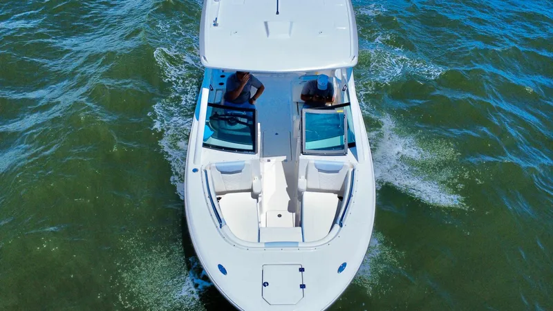 Slide: The Image of 2025 Robalo R257 Dual Console boat cruising on open water, aerial view. - 3