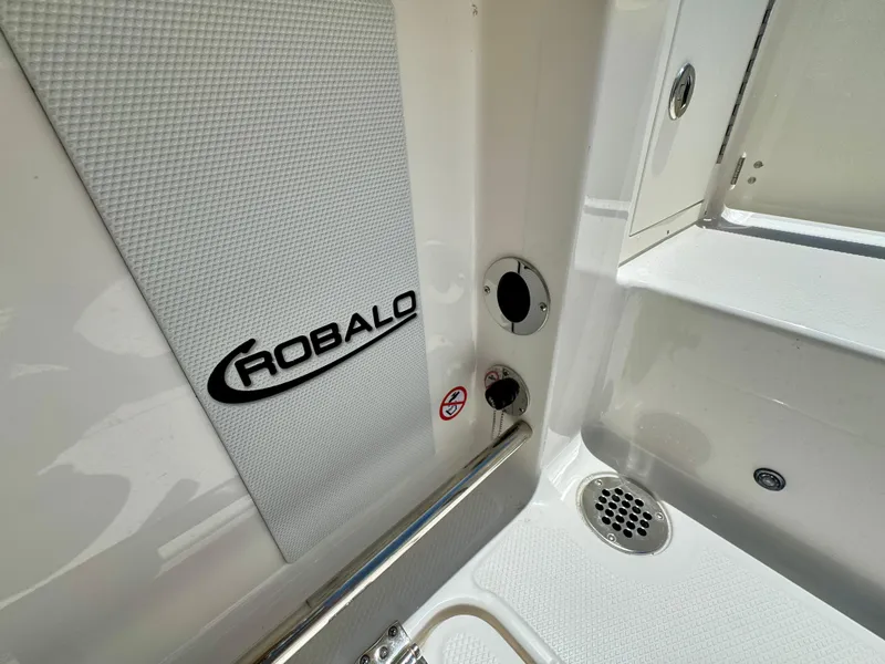 Slide: The Image of 2025 Robalo R257 Dual Console boat interior detail with logo and drainage system. - 30