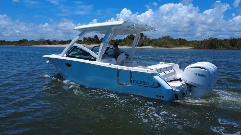 Slide: The Image of 2025 Robalo R257 Dual Console boat cruising on a sunny day with Yamaha engine. - 4