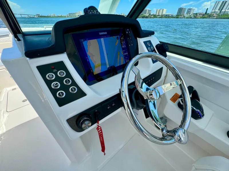 Slide: The Image of 2025 Robalo R257 Dual Console helm with navigation display and steering wheel. - 44