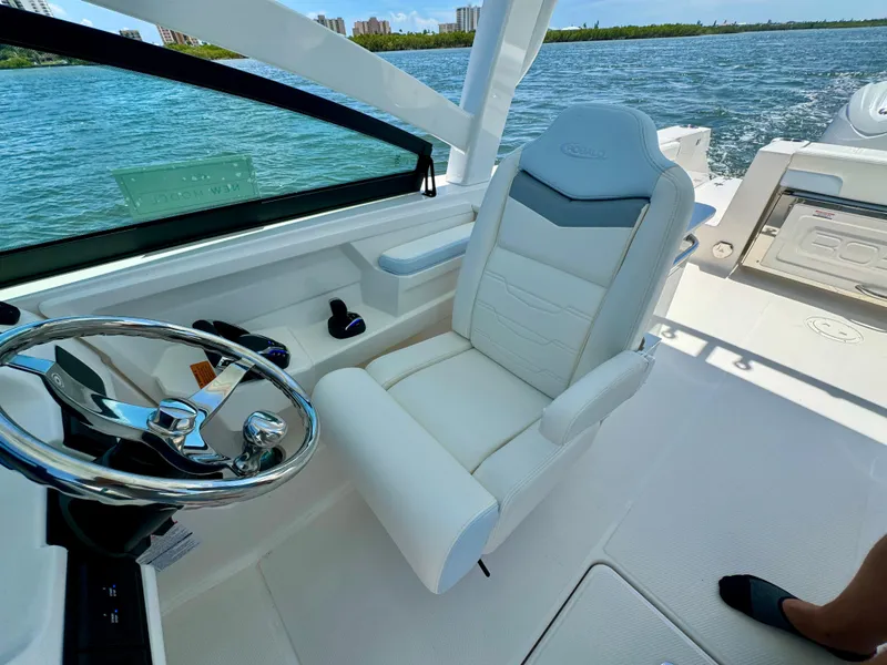 Slide: The Image of 2025 Robalo R257 Dual Console boat interior with steering wheel and comfortable seating. - 45