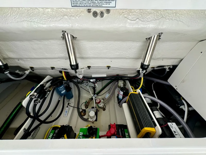 Slide: The Image of 2025 Robalo R257 Dual Console engine compartment with wiring and battery setup. - 48