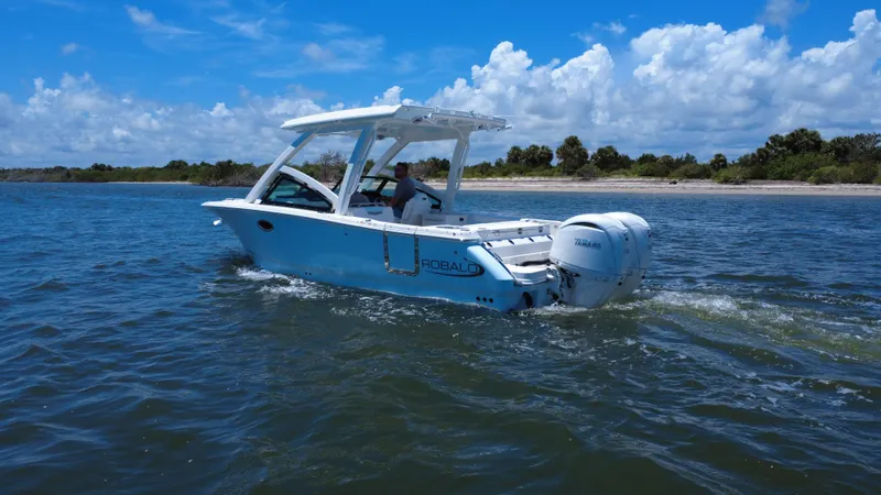 Slide: The Image of 2025 Robalo R257 Dual Console boat cruising on a sunny day near the shore. - 5