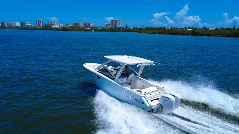Slide: The Image of 2025 Robalo R257 Dual Console cruising on blue water near city skyline. - 7
