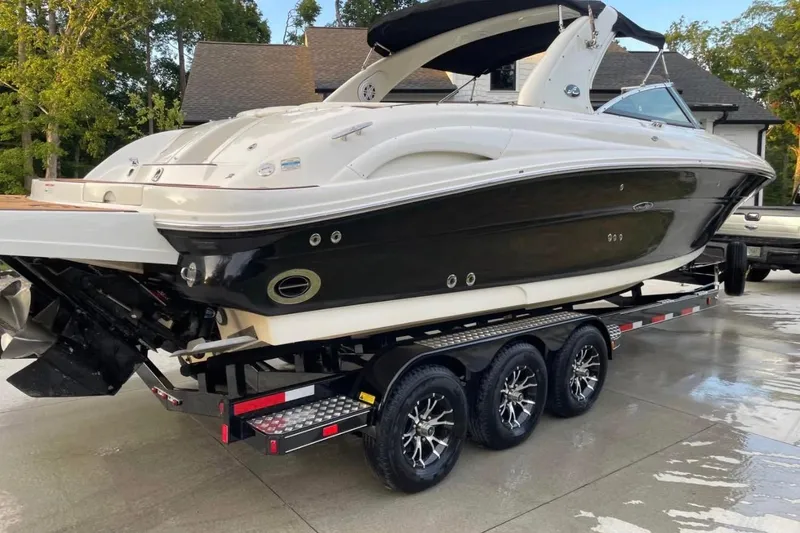 The Image of 2007 Sea Ray 290 SLX boat on trailer, parked outdoors. - 1