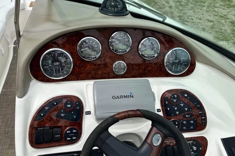Slide: The Image of 2007 Sea Ray 290 SLX dashboard with Garmin navigation and wood grain paneling. - 12