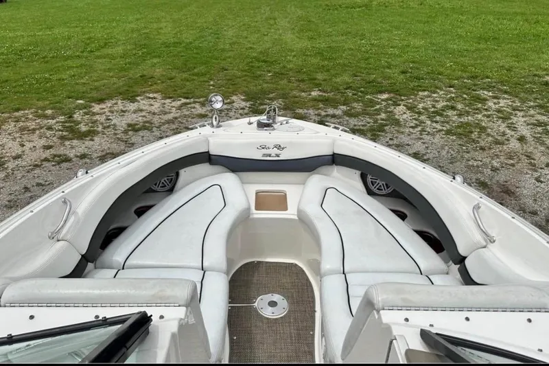 Slide: The Image of 2007 Sea Ray 290 SLX boat interior with white seating and green grass background. - 16