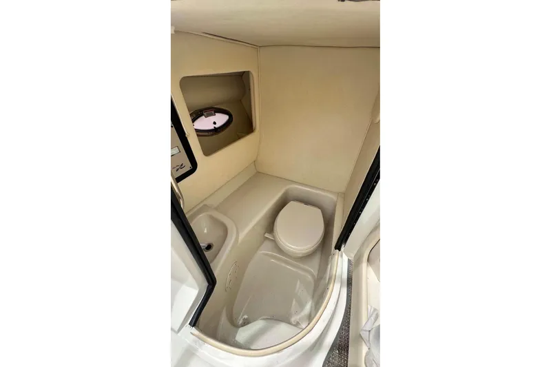 Slide: The Image of 2007 Sea Ray 290 SLX boat interior with compact bathroom and porthole window. - 17