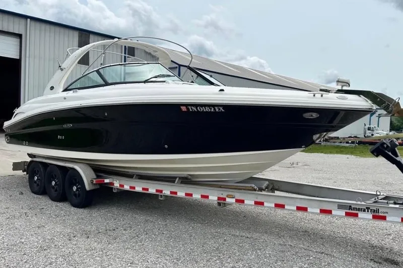 Slide: The Image of 2007 Sea Ray 290 SLX boat on trailer outside a warehouse. - 2