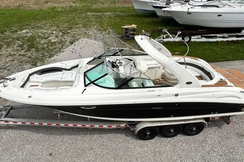 Slide: The Image of 2007 Sea Ray 290 SLX boat on trailer, parked on gravel near grass. - 8