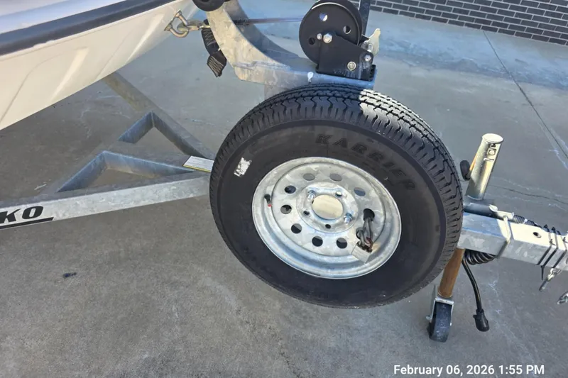 Slide: The Image of Trailer wheel of a 2018 Mako Pro Skiff 17 CC boat on concrete surface. - 2