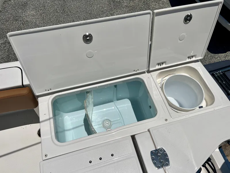 Slide: The Image of Robalo 266 Cayman 2025 boat with open storage compartments and bucket. - 11