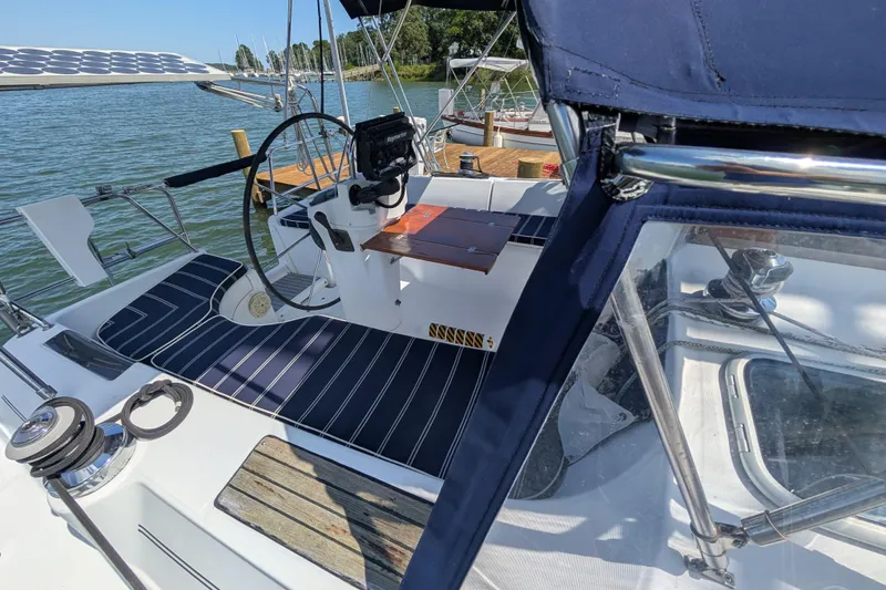 Slide: The Image of Cockpit of 1999 Beneteau Oceanis 361 sailboat with striped seating and steering wheel. - 10