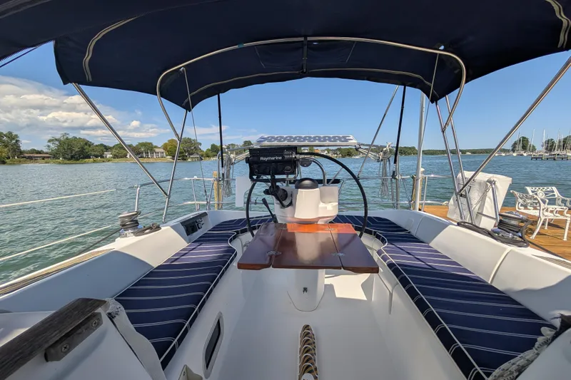 Slide: The Image of Cockpit of 1999 Beneteau Oceanis 361 sailboat with striped seating and scenic water view. - 13