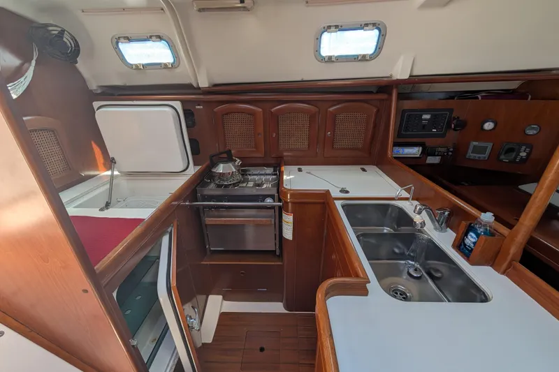 Slide: The Image of Interior of 1999 Beneteau Oceanis 361 yacht kitchen with wood cabinetry and dual sinks. - 16
