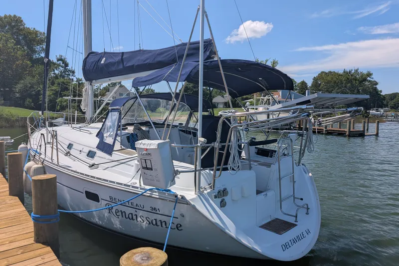 Slide: The Image of 1999 Beneteau Oceanis 361 sailboat docked, featuring blue canopy and sleek design. - 2