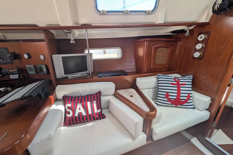Slide: The Image of Interior of 1999 Beneteau Oceanis 361 sailboat with nautical-themed cushions and wooden accents. - 20