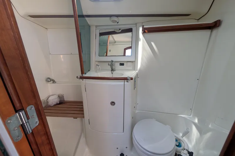 Slide: The Image of Bathroom interior of 1999 Beneteau Oceanis 361 yacht, featuring sink, toilet, and wooden accents. - 26