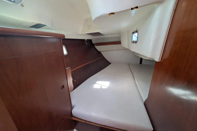 Slide: The Image of 1999 Beneteau Oceanis 361 cabin interior with wooden finish and cozy sleeping area. - 27