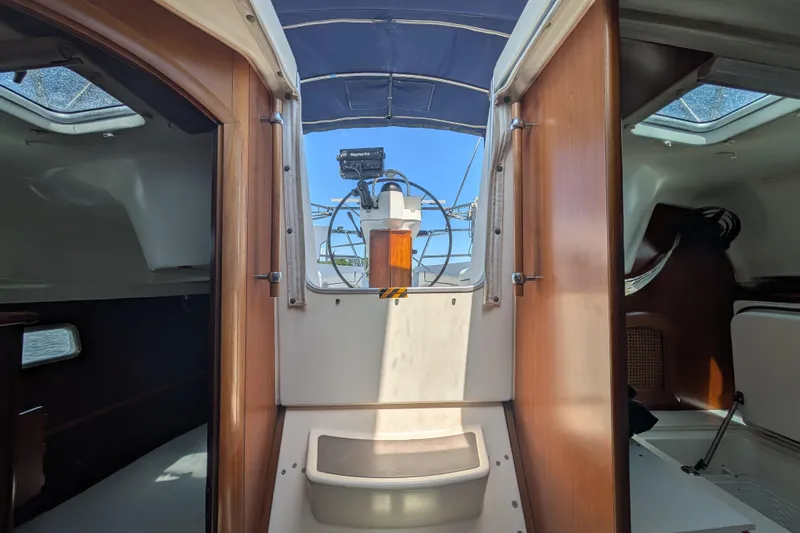 Slide: The Image of Interior view of 1999 Beneteau Oceanis 361 sailboat, featuring wooden cabin doors and helm. - 28