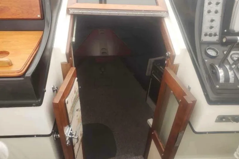 Slide: The Image of Interior view of 1985 Carver 28 Riviera boat cabin with open wooden doors. - 11