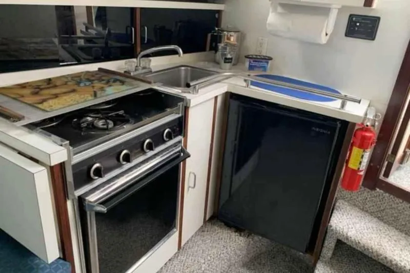 Slide: The Image of Compact kitchen in 1985 Carver 28 Riviera boat with stove, sink, and fridge. - 13