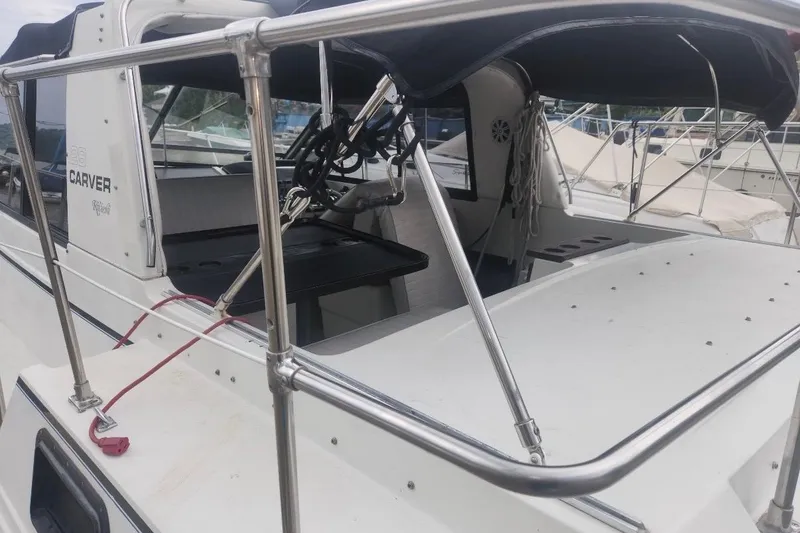 Slide: The Image of 1985 Carver 28 Riviera boat with stainless steel railings and covered seating area. - 16
