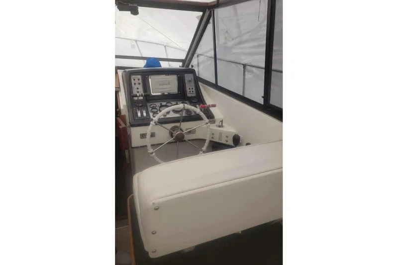 Slide: The Image of 1985 Carver 28 Riviera boat helm with steering wheel and navigation equipment. - 5